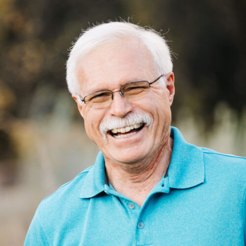 Elderly man laughing outdoors