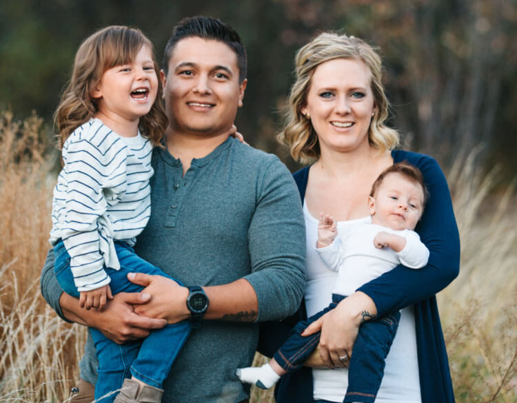 Family of four smiling outdoors