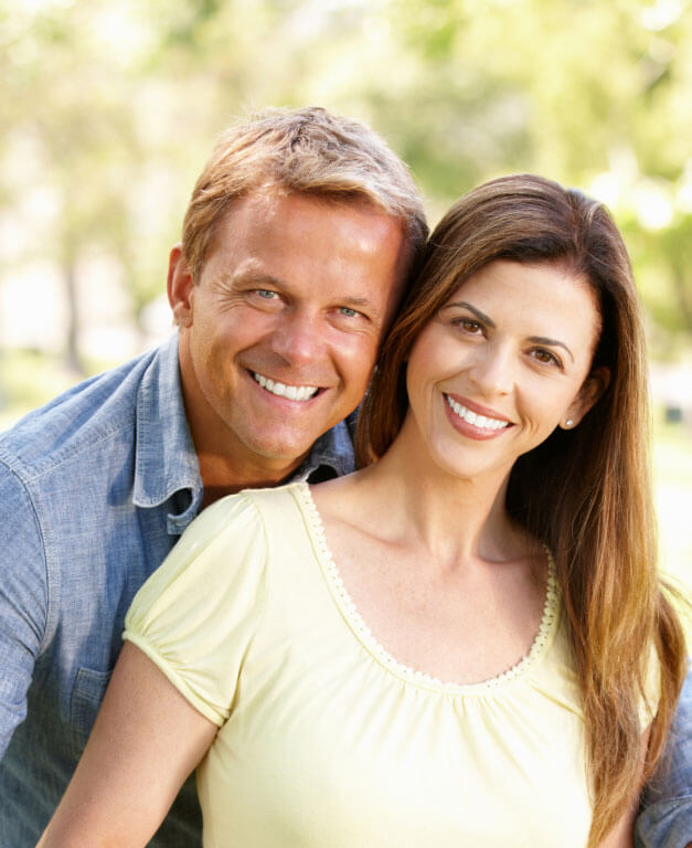 Middle-aged couple smiling outdoors