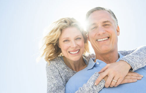 Middle-aged couple smiling outdoors