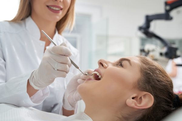 woman getting her teeth examined by her dentist