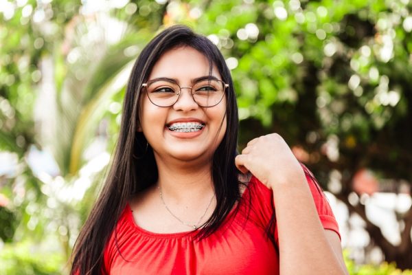 young woman wearing braces smiles